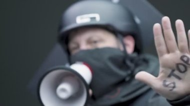 Protestocu adam siyasi mitingde megafona bağırıyor. Sosyal aktivist ırkçılığa karşı konuşuyor. Direniş isyanı