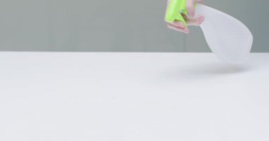 Kadın eli dezenfektan spreyi ve mendille masa yüzeyini temizler. Ofis temizlikçisi günlük rutin işler yapıyor.