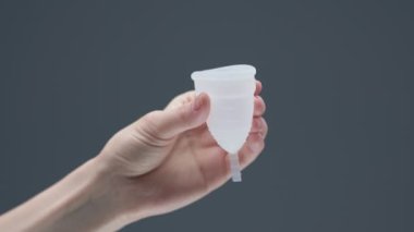 Tekrar kullanılabilir regl bardağını sıkan bir kadın. Sıfır adet hijyeni. Döngü için çevre dostu alternatif