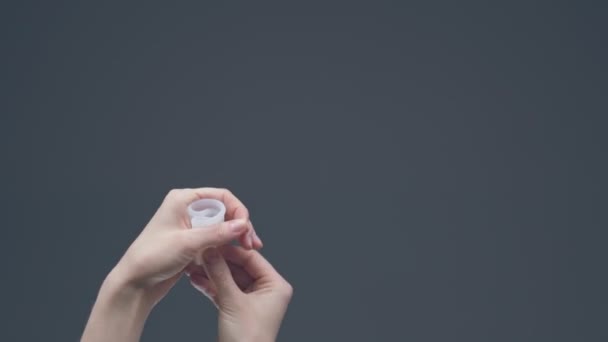 Weibliche Hand demonstriert Einsatz der wiederverwendbaren Menstruationstasse. Zero Waste Menstruationshygiene. Öko-Alternative für Zeiten — Stockvideo