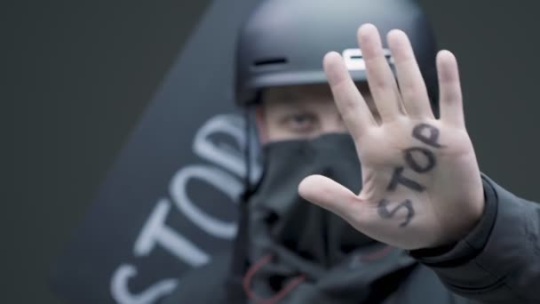 Close up de jovem manifestante em capacete e máscara mostrando na parada título mão, protestos nos EUA — Vídeo de Stock