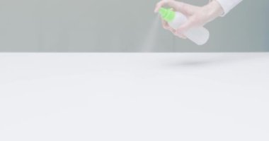 Kadın el temizleme masası yüzeyi, salgın sırasında antibakteriyel dezenfekte edici sprey ile ofisi dezenfekte etmek.