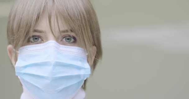 Médico positivo mujer joven en la máscara protectora de la cara médica mira a la cámara. Detener el concepto de brote de virus corona — Vídeos de Stock