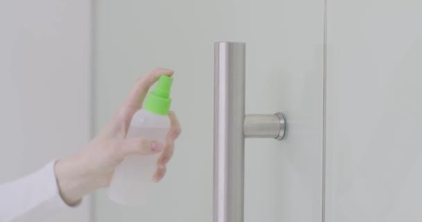 Female hand disinfecting office door handle by wipe with antibacterial sanitizer spray during coronavirus outbreak — Stock Video