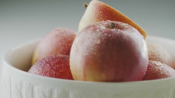 Makro välsmakande naturliga äpplen i vattendroppar roterande i vas, hög med röda aptitretande frukter i dagg, närbild studio video — Stockvideo