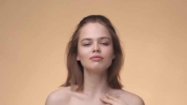 Bonito modelo de menina com pele saudável e cabelos, ombros nus. publicidade de vídeo para produtos cosméticos naturais — Vídeo de Stock