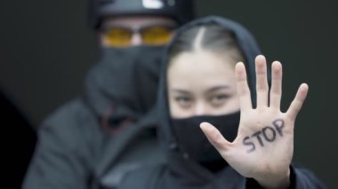 Avucunda yazı yazan kızın yakın portresi. Genç kadın ve erkek küresel ısınma ve şiddeti protesto ediyor