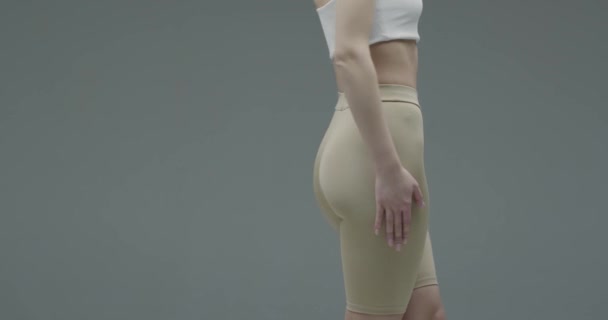 Fit weibliches Gesäß und Hüften in sportlicher Komfort-Sportbekleidung auf grauem Hintergrund, Frauengesundheit und Cellulite-Konzept — Stockvideo