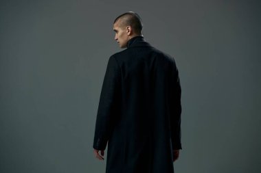 Siyah ceketli cesur genç adam ya da gri stüdyo geçmişi olan bir suçlu.