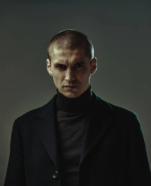 Asık suratlı, siyah takım elbiseli yakışıklı adam ya da gri arka planda suçlu, stüdyo fotokopi alanı olan erkek portresi