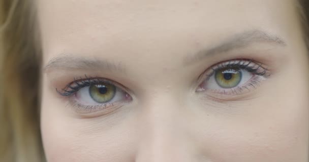Un primer plano de cara femenina bonita, ojos mirando a la cámara. Tratamiento anti envejecimiento del cuidado de la piel, cirugía de la vista, salud de la visión — Vídeos de Stock