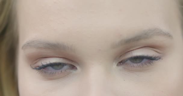 Крупный план женского лица, привлекательная девушка с зелеными глазами, натуральный макияж и длинные ресницы, смотрящие в камеру — стоковое видео