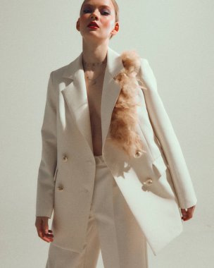 Beyaz takım elbiseli, romantik stil sahibi, modern kadın çıplak vücutlu, stüdyo resimli, neşeli kostümlü güzel kız.