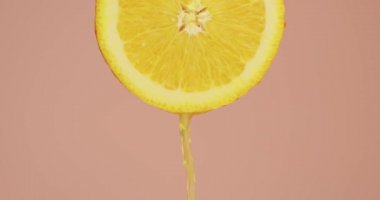 Portakal suyu, pembe stüdyo arka planındaki doğal meyvelerin üzerine akıyor. Fotokopi alanı, taze lezzetli yaz vitaminleri.