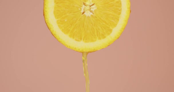 Sinaasappelsap stroomt naar beneden op natuurlijk fruit op roze studio achtergrond met kopieerruimte, verse heerlijke zomer vitaminen — Stockvideo