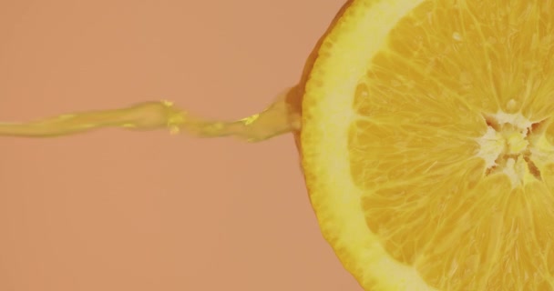 Sinaasappelsap stroomt op natuurlijke bio fruit op studio achtergrond met kopieerruimte, verse heerlijke vitaminen — Stockvideo