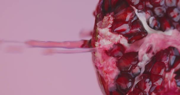 Succo che scende dalla frutta melograno su sfondo rosa studio con spazio copia, close up video verticale — Video Stock