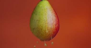 Armut suyunun parlak turuncu arkaplanda fotokopi alanı ve taze yaz vitaminleriyle aktığı 4K video.