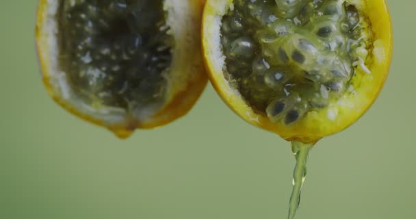 Gros plan Vidéo 4k de granadilla Juice coulant de fruits exotiques naturels de la passion sur fond de studio vert — Video