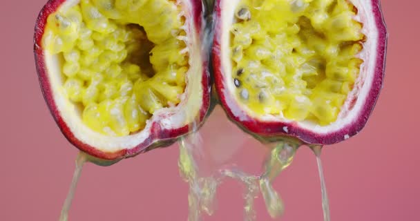 Закрыть видео страсти фруктовый сок стекает вниз на розовом студийном фоне с копировальным пространством для рекламы здорового питания — стоковое видео