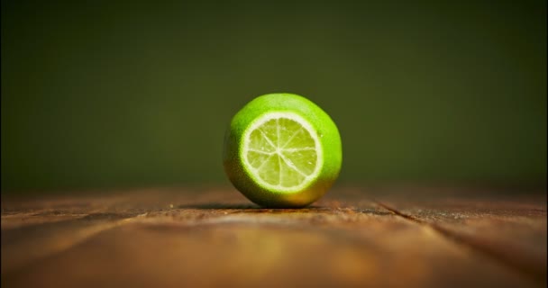 Stoppa rörelse av färsk citrus lime skivning på trä skärbräda i köket. 4k video på grön bakgrund. Vegansk matlagning — Stockvideo