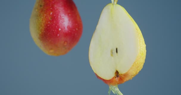 Nahaufnahme Video-Birnensaft, der von Früchten auf blauem Studiohintergrund herunterfließt, mit Kopierplatz für Werbung für gesunde Ernährung — Stockvideo