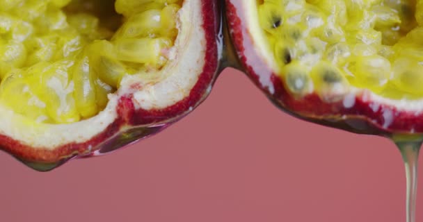 Luk op video juice dråber flyder ned fra lidenskab frugter på lyserød studie baggrund for annonce sund kost – Stock-video