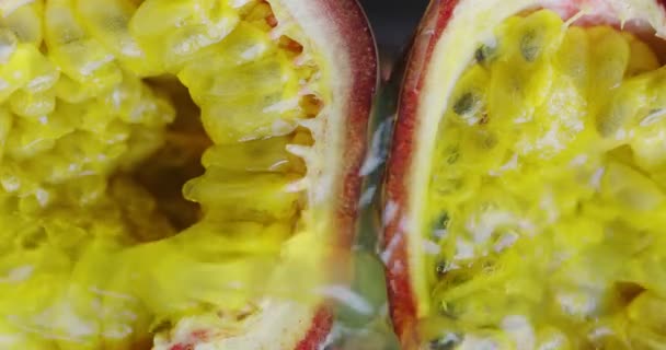 Vídeo vertical de cerca 4K. Salpicaduras de jugo que fluyen en la pulpa jugosa natural de fruta de la pasión — Vídeos de Stock