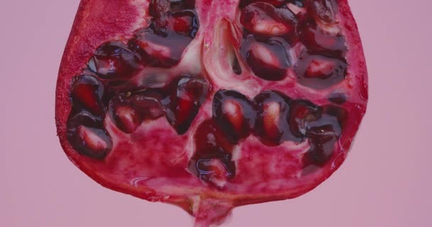 쥬스는 분홍색 스튜디오 배경에 있는 천연적 인 붉은 석류 열매에서 흘러내리고 신선 한 채식주의자 비타민은 — 비디오