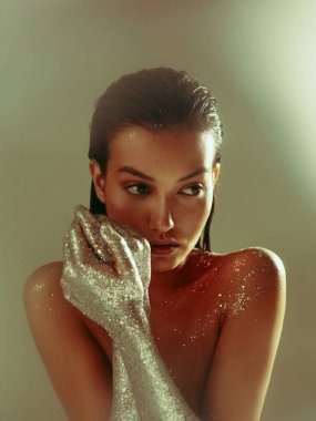 Gümüş parıldayan eller, parıltılı vücut sanatı ile poz veren genç çıplak kız, yaratıcı stüdyo kadınları portresi.