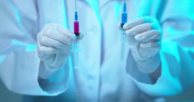 Doktor ve aşı ve aşı için aşı. Doktorlar ellerinde aşı ya da ilaç olan şırıngalar gösteriyor. Videoyu kapat