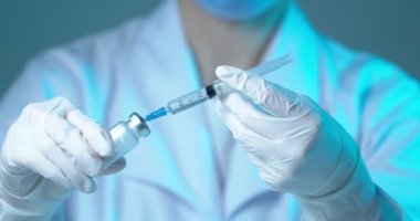 Doktorun elindeki şırıngayla antibiyotik ilacını suyla doldurduğu videoyu kapat. Sağlık hizmetleri kavramı