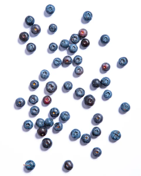 Hintergrund sind frische Blaubeeren. Blaubeeren isoliert auf weißem Hintergrund. Gesunder veganer Snack aus Beeren. Ansicht von oben — Stockfoto