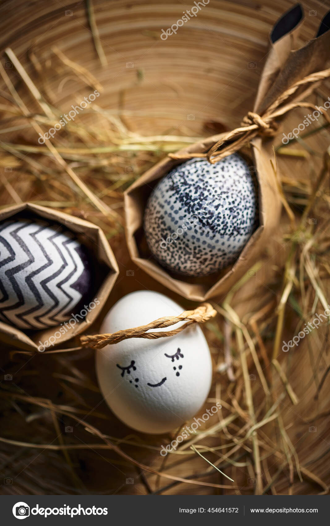 Easter eggs on straw. Cute angel egg lying on hay, greeting festive card on  springtime religious holiday Stock Photo by ©georgeeb22 454641572