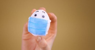 Tıbbi maskeli komik Paskalya Yumurtası. Covid-19 salgını sırasında tatil. Stüdyo videosunu kapat. Kukla gösterisi.