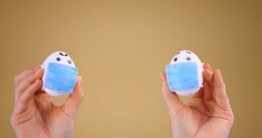 Sosyal uzaklık. Korunaklı tıbbi yüz maskeli Paskalya Yumurtaları Coronavirus covid-19 salgını sırasında mesafeyi koruyor.