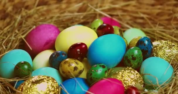 Bunte Ostereier, die auf Heu liegen, rotierend, Nahaufnahme-Video. Religiöser christlicher Feiertag im Frühling — Stockvideo