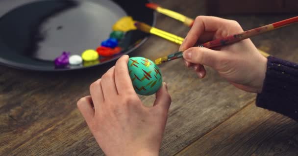 Female artist hands painting on Easter egg preparing for christian religious holiday, close up video — Stock Video