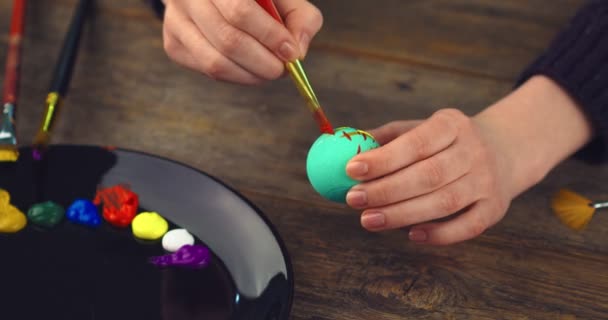 Celebrating Easter. Close up video of artists hands painting on egg. Preparations for christian religious holiday — Stock Video