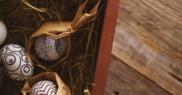 Firar påsk, dekorerade ägg på hö. Närbild video av roterande trälåda för kristen religiös semester. — Stockvideo