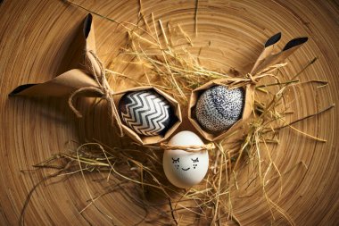 Saman üstünde paskalya yumurtası. Samanlıkta yatan tatlı melek yumurtası, bahar dini bayramında bayram kartı.