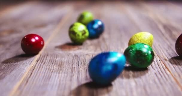 Pasen kleurrijke kwartel eieren rollen op houten tafel, close-up video van christelijke religieuze traditie — Stockvideo