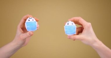 Sosyal uzaklık. Tıbbi maskeli komik Paskalya Yumurtaları. Covid-19 salgını sırasında tatil. Videoyu kapat