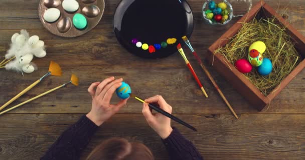 Πασχαλινή χριστιανική θρησκευτική γιορτή. Top view βίντεο με γυναικεία χέρια ζωγραφική στα αυγά. Εργαστήρι καλλιτεχνών — Αρχείο Βίντεο