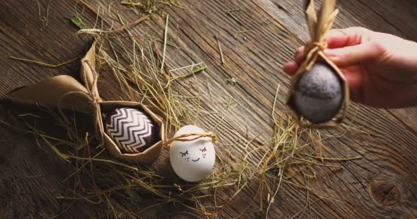 Mignon Pâques emballé oeuf ange tendre et des œufs élégants avec des oreilles en papier sur le foin et le fond en bois, vidéo vue du dessus — Video