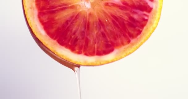 Σιρόπι χυμού φρούτων που ρέει κάτω από τη στροφή γκρέιπφρουτ. Βιταμίνες, υγιεινή διατροφή έννοια, κοντά — Αρχείο Βίντεο