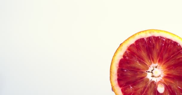 Видео сочного грейпфрута, вращающегося на белом фоне студии с копировальным пространством. Витамины, концепция здорового питания — стоковое видео