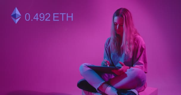 NFT Kryptoart-Konzept. Ein junges hübsches Designermädchen zeichnet eine Illustration auf einem Tablet, das bei einer Kryptowährungsauktion zum Verkauf steht. Ethereum-Zähler auf Neonlicht-Hintergrund. — Stockvideo