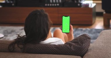 Yeşil ekranlı telefonlu kadın görüntüsü. Chromakey işaretleri takip ediyor. Kız video haberleri izliyor.