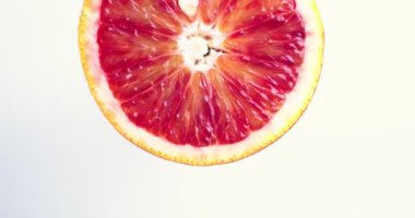 Beyaz stüdyo arka planında dönen greyfurt turunçgillerinin videosu. Vitaminler, sağlıklı beslenme konsepti, yakın çekim.